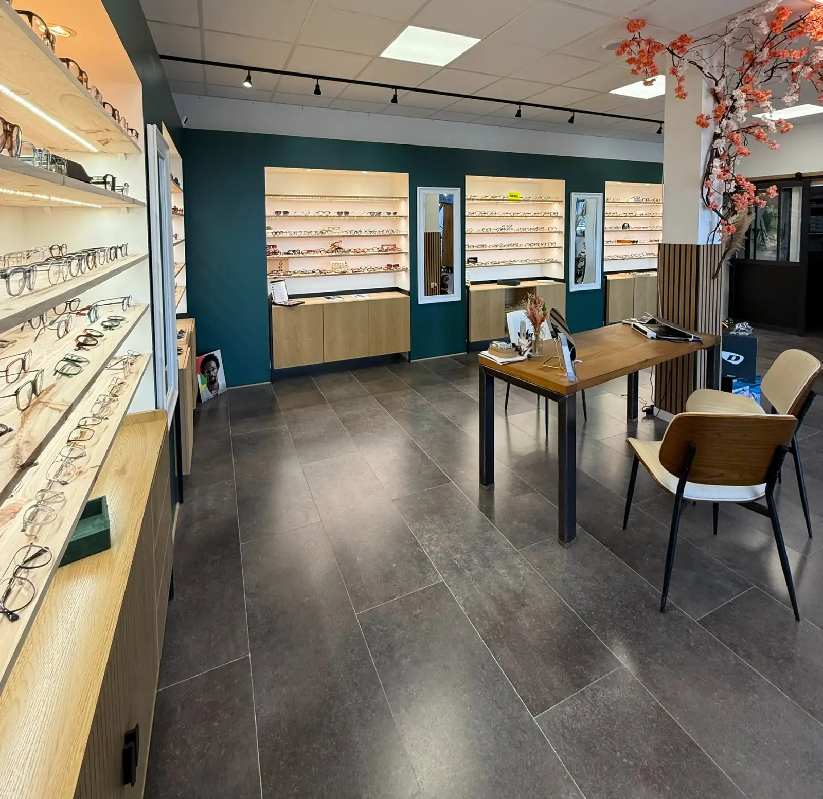 Vue d'ensemble du magasin : murs de montures et table de conseil